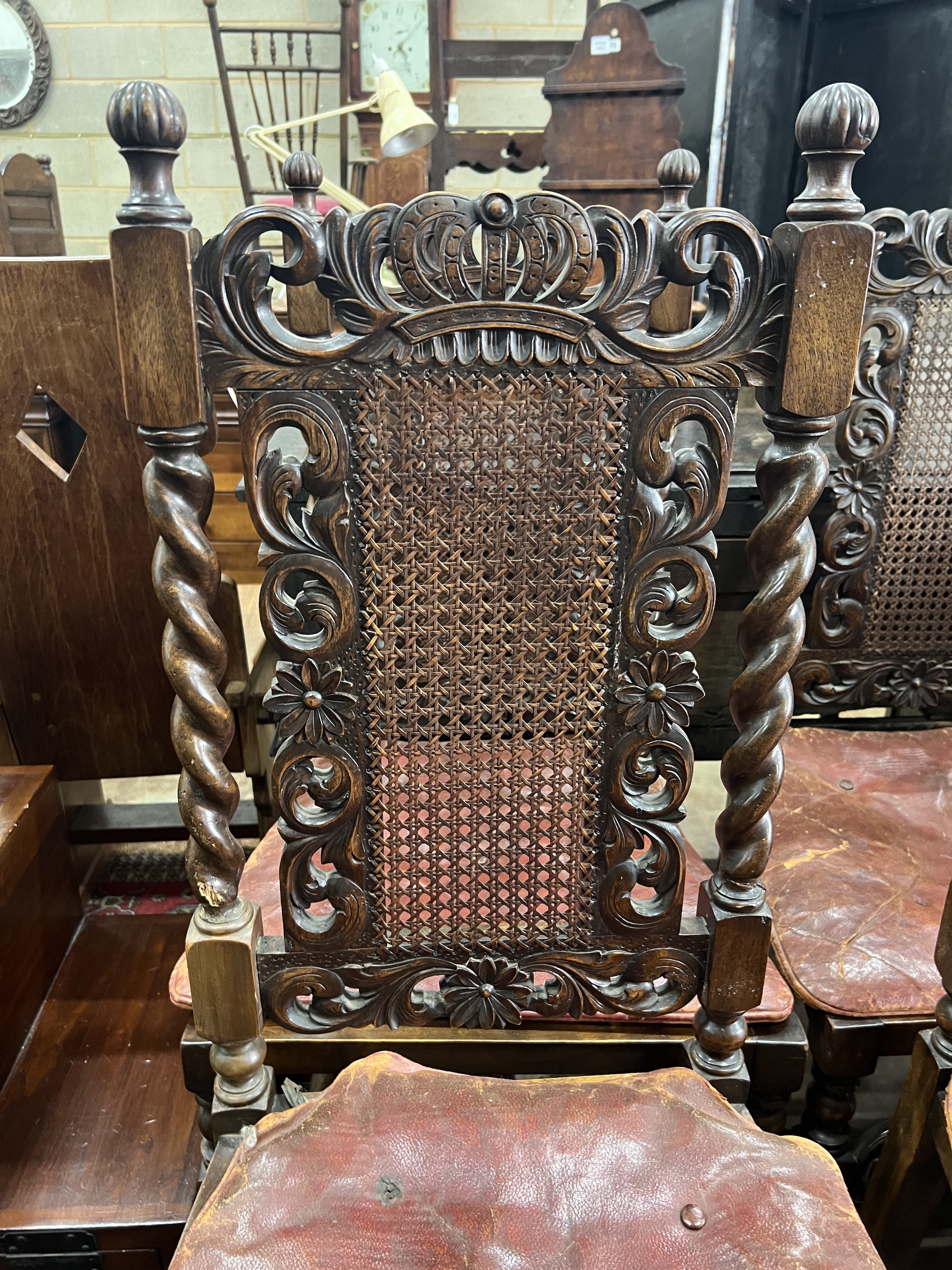 A set of six Jacobean revival carved caned beech dining chairs with leather squab seats
